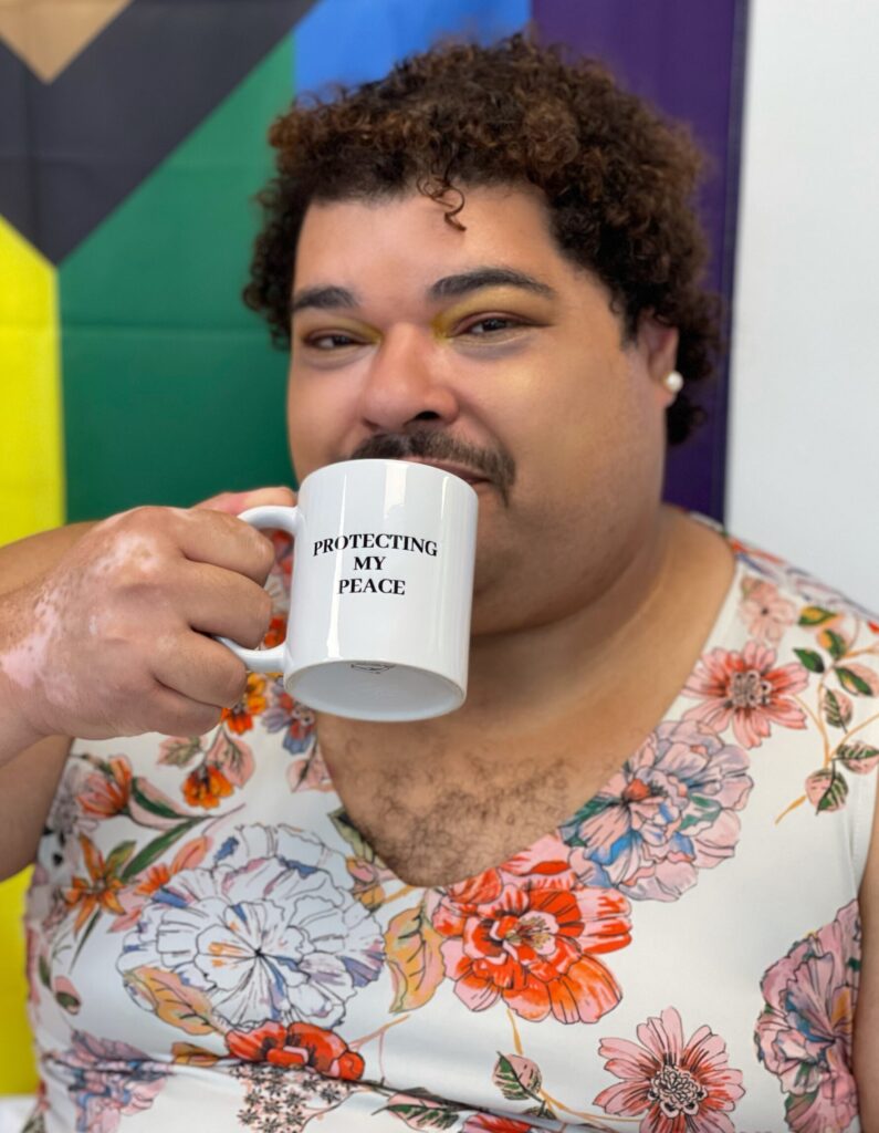 An individual holding a mug that says "Protecting my peace."