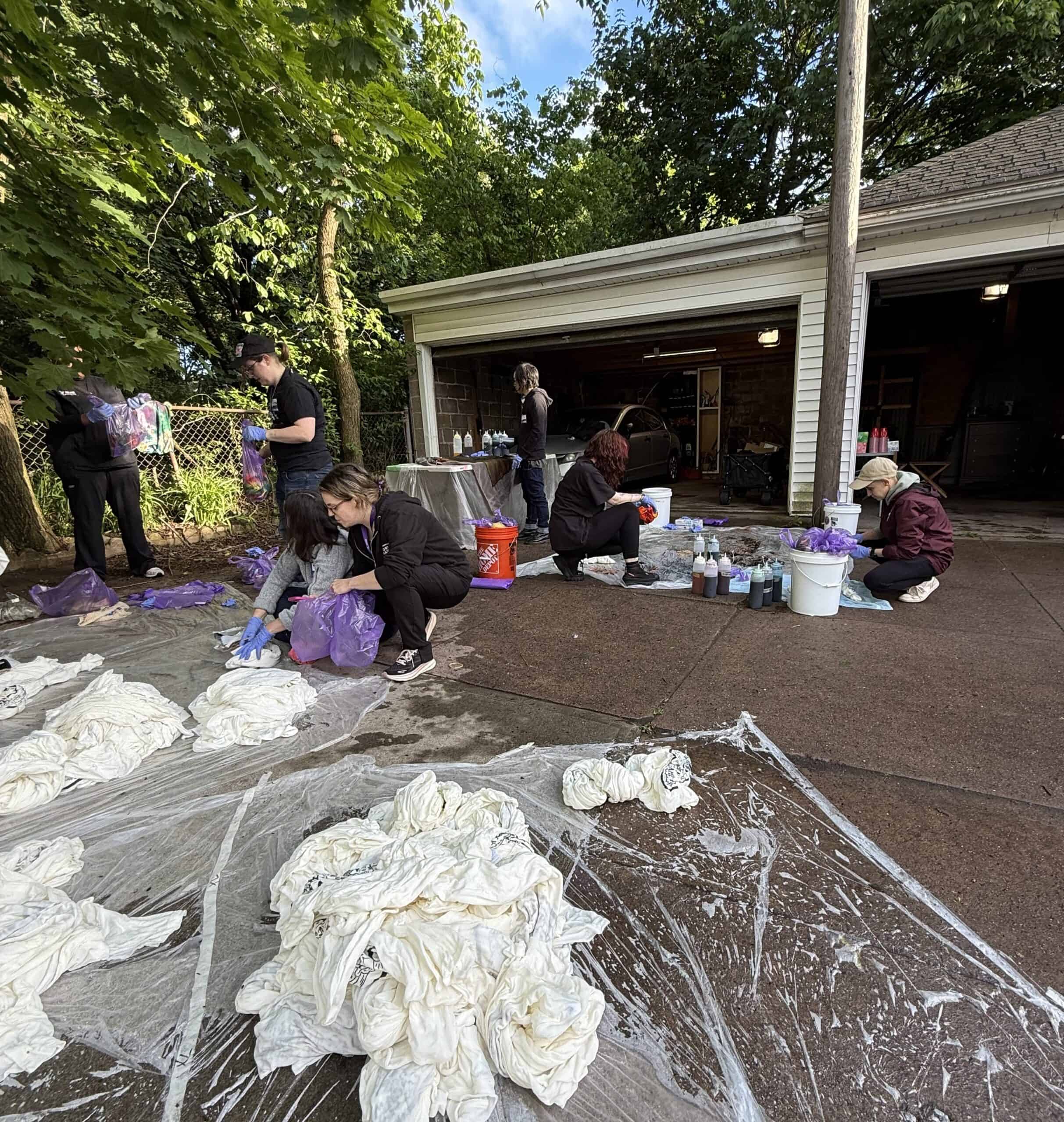 Photo of Anchor Health staff and volunteers tie-dying Pride t-shirts.